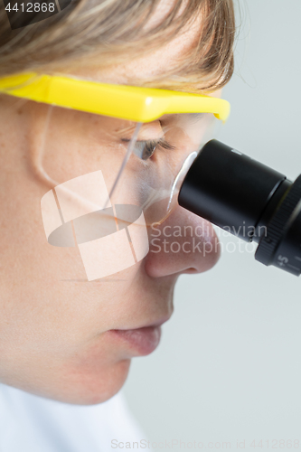 Image of Scientist looking through a microscope