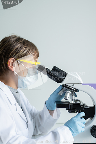 Image of Scientist looking through a microscope