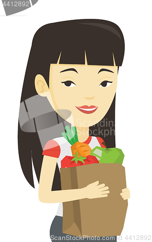 Image of Happy woman holding grocery shopping bag.