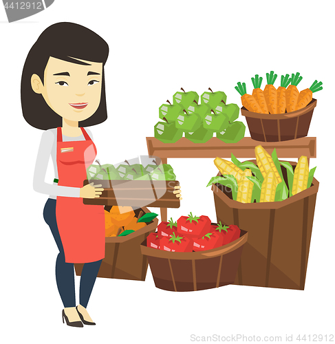 Image of Supermarket worker with box full of apples.