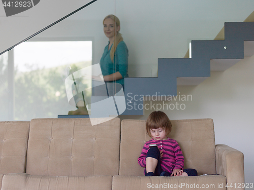 Image of little girl playing games on smartphone