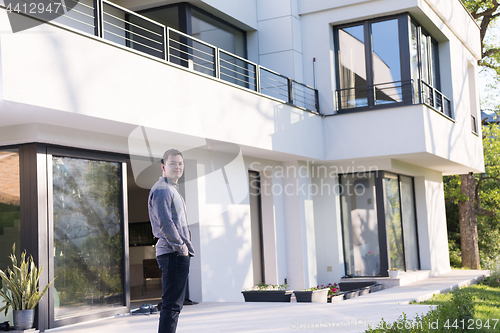 Image of man in front of his luxury home villa