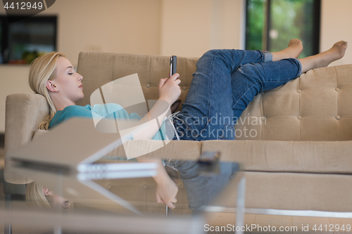 Image of woman on sofa using tablet computer