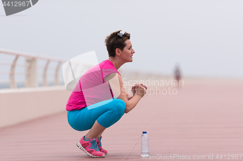 Image of woman stretching and warming up on the promenade