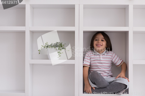 Image of young boy posing on a shelf