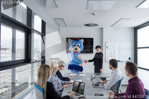 Image of boss dresed as bear having fun with business people in trendy of