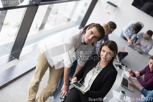 Image of Two Business People Working With Tablet in office