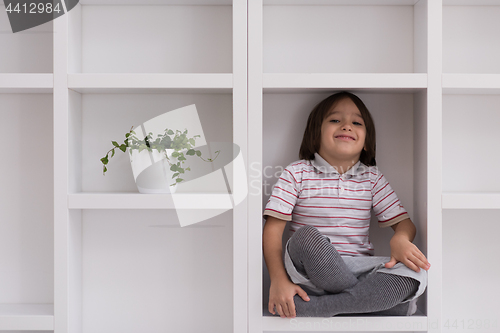 Image of young boy posing on a shelf