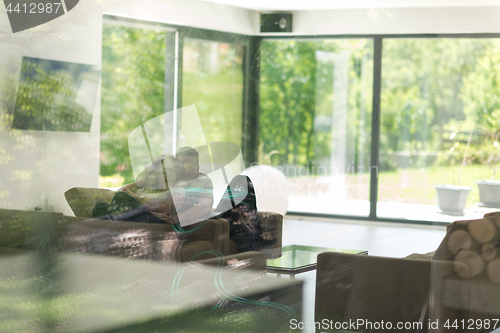 Image of couple relaxing at  home with tablet and laptop computers