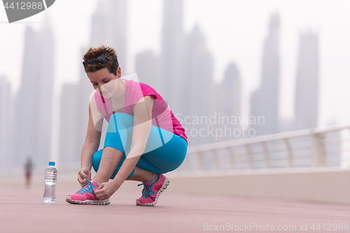 Image of woman tying shoelaces on sneakers