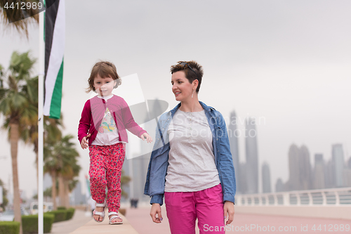 Image of mother and cute little girl on the promenade