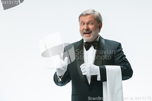 Image of Senior waiter holding white towel