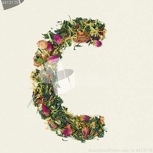 Image of Tea leaf with flowers and fruits, letter C on white background, top view