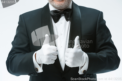 Image of Senior waiter in white gloves