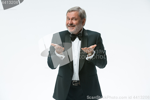 Image of older businessman in a suit with a bow tie, isolated over white