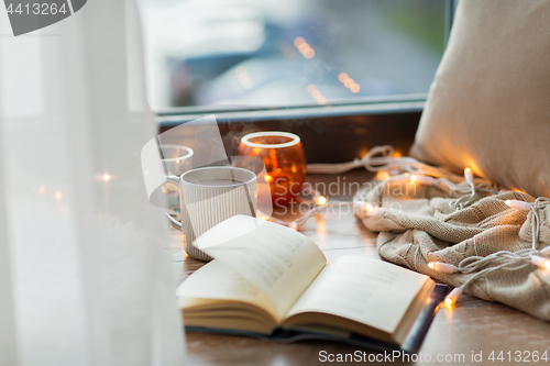 Image of book and coffee or hot chocolate on window sill