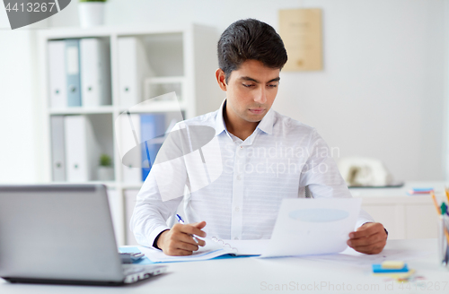 Image of businessman working with papers at office