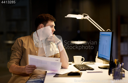 Image of businessman with papers working at night office