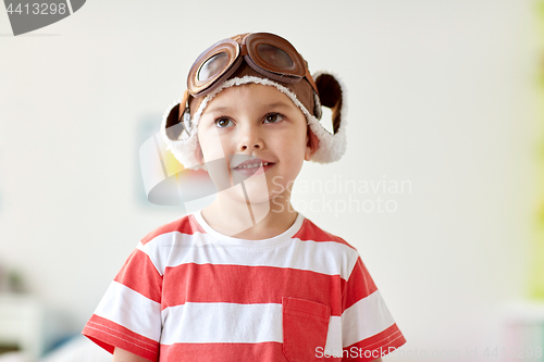 Image of happy little boy in pilot hat at home