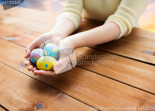 Image of close up of woman hands with colored easter eggs