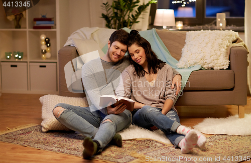 Image of happy couple reading book at home