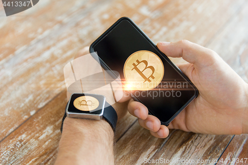 Image of close up of bitcoin on smartphone and smart watch