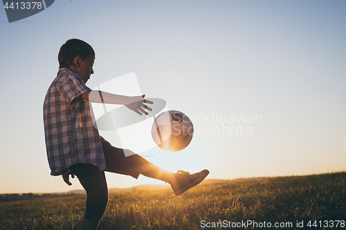 Image of Young little boy playing in the field  with soccer ball.