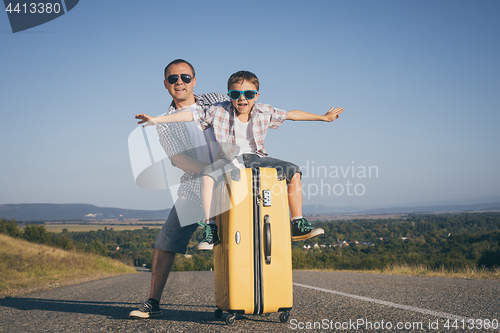 Image of Father and son standing in the park at the day time.