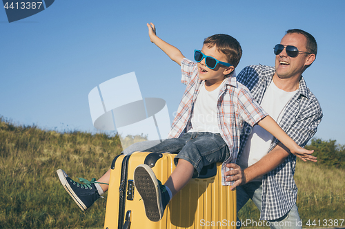 Image of Father and son standing in the park at the day time.