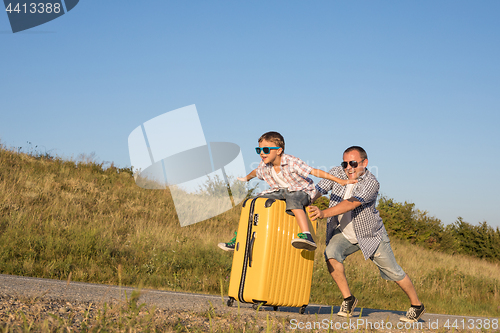 Image of Father and son standing in the park at the day time.