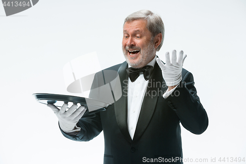 Image of Senior waiter holding tray