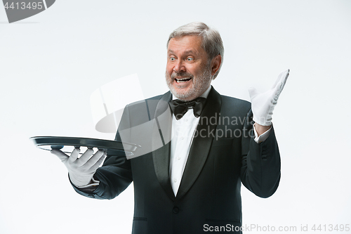 Image of Senior waiter holding tray