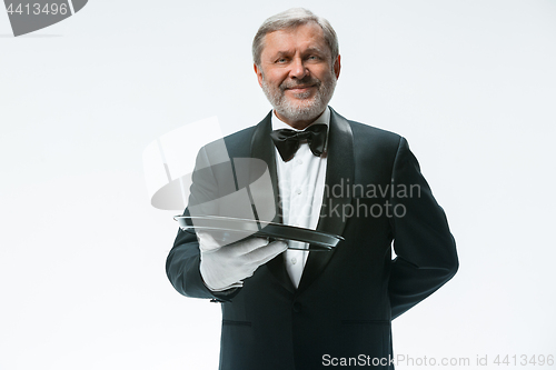 Image of Senior waiter holding tray