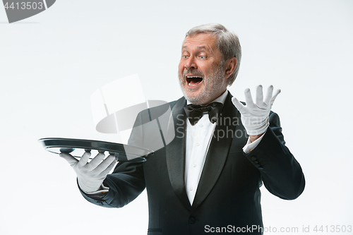 Image of Senior waiter holding tray