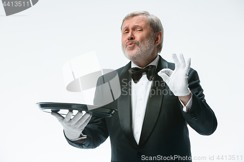 Image of Senior waiter holding tray