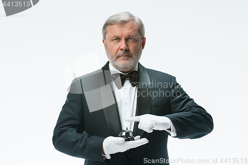 Image of Senior waiter holding bell