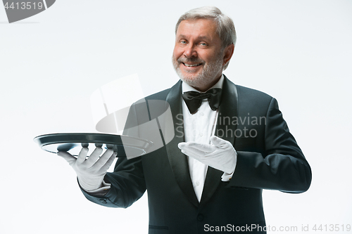 Image of Senior waiter holding tray