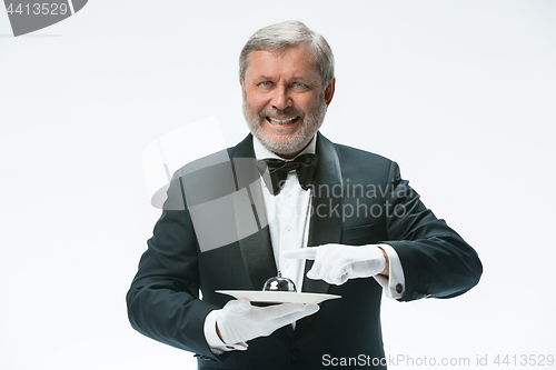 Image of Senior waiter holding bell