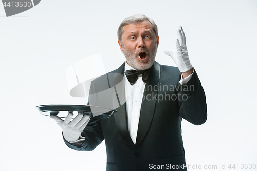 Image of Senior waiter holding tray