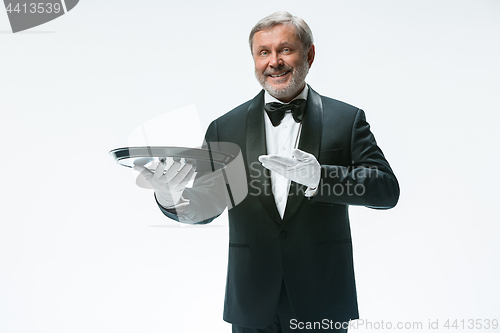 Image of Senior waiter holding tray