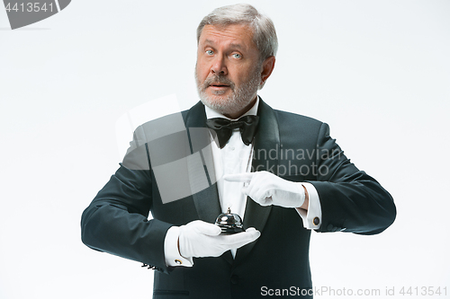 Image of Senior waiter holding bell