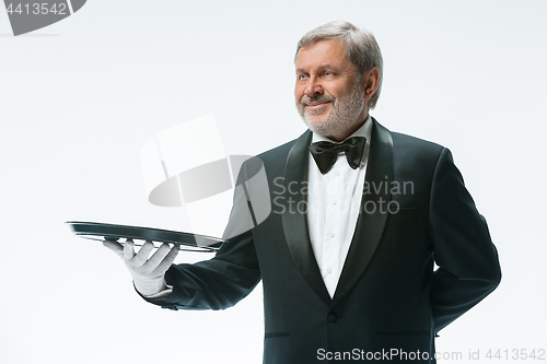 Image of Senior waiter holding tray