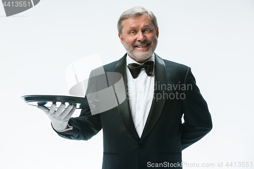 Image of Senior waiter holding tray