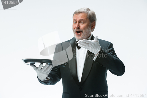 Image of Senior waiter holding tray