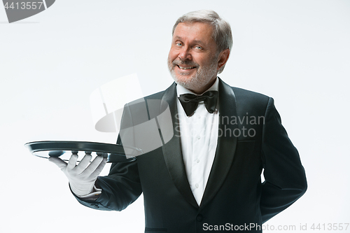 Image of Senior waiter holding tray