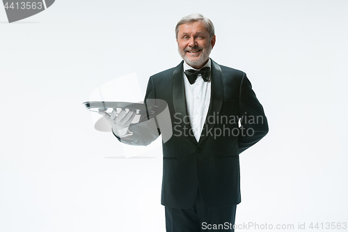 Image of Senior waiter holding tray