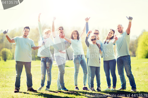 Image of group of volunteers showing thumbs up in park