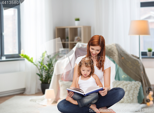 Image of happy mother with little daughter reading book