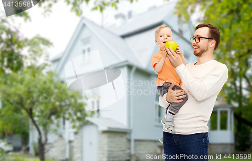 Image of happy father and little son with green apple