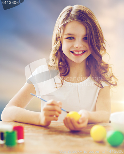 Image of happy girl coloring easter eggs